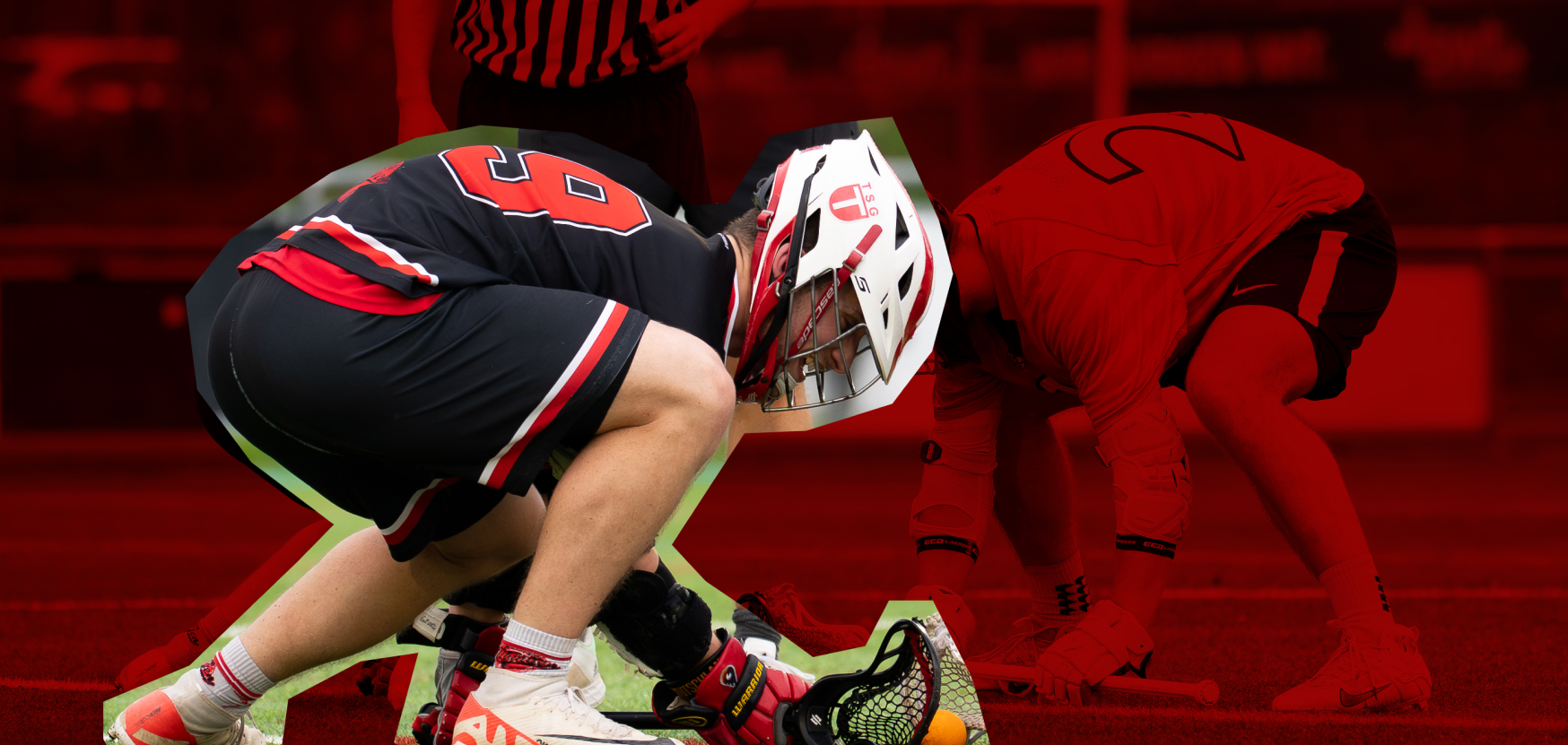 Ein Lacrosse-Spieler kniet auf dem Boden, trägt eine Helm- und Schutzausrüstung und hält den Schläger in der Nähe eines Balls auf dem Spielfeld.